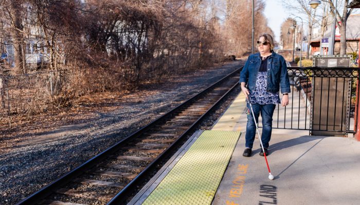 visually impaired woman at train station. demonstrating how her cane helps her get around.