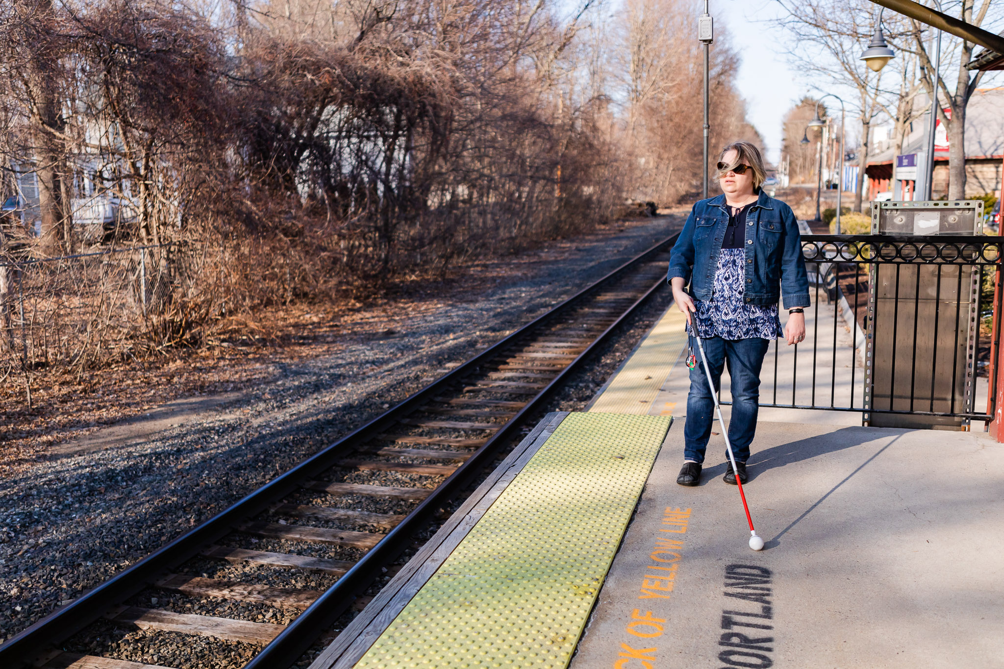 visually impaired woman at train station. demonstrating how her cane helps her get around.