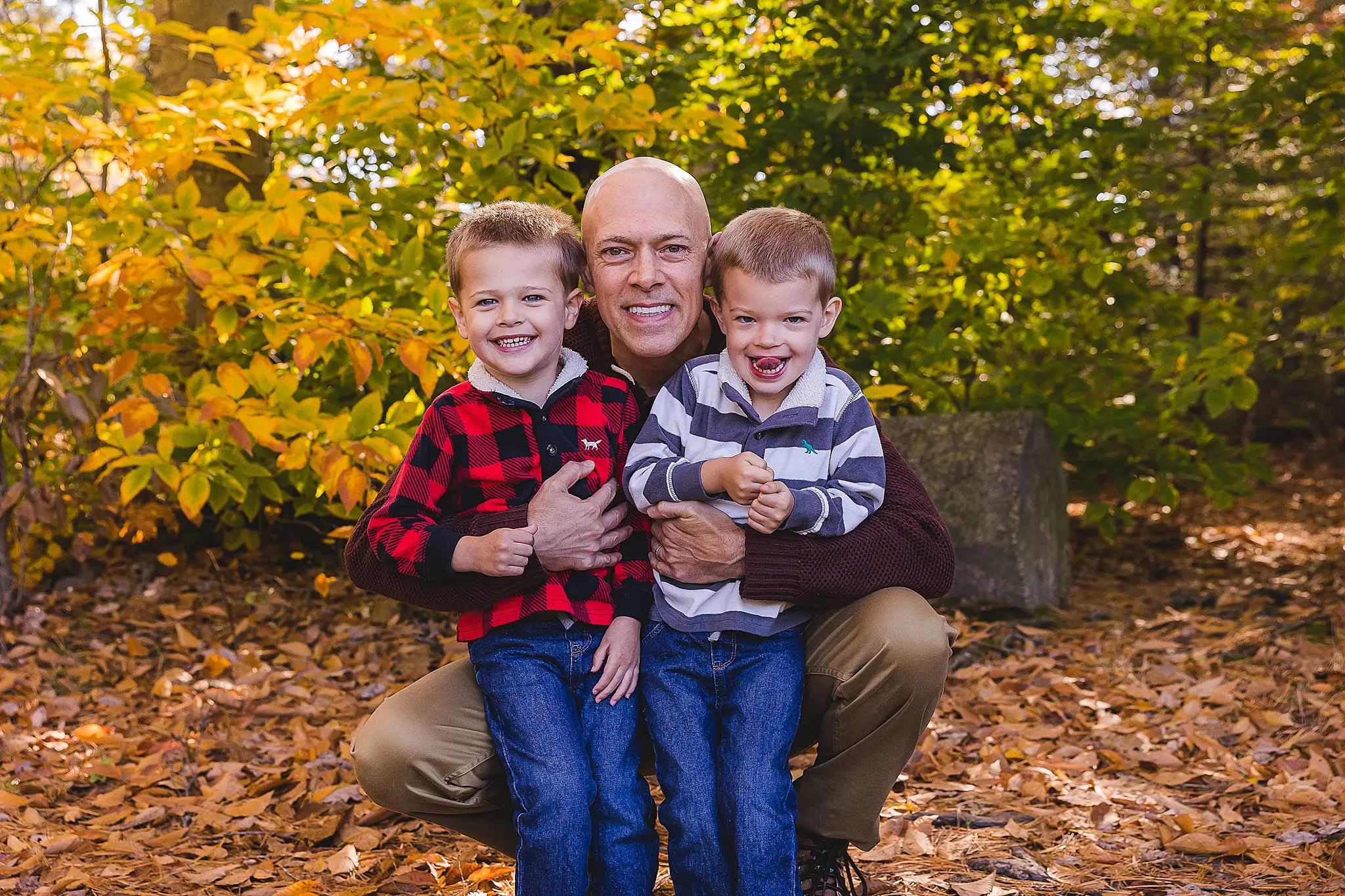 family photography with twins twins snuggle and keep warm with dad in winter photo sessions in NH